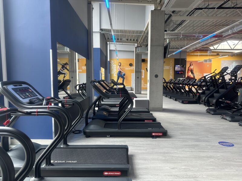 Cardio at Just GYM Leszno - bikes and ellipticals overlooking the room, clear zone markings.