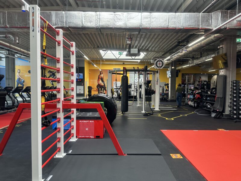 An open space with punching bags at Just GYM Leszno - a mat and boxing training area.