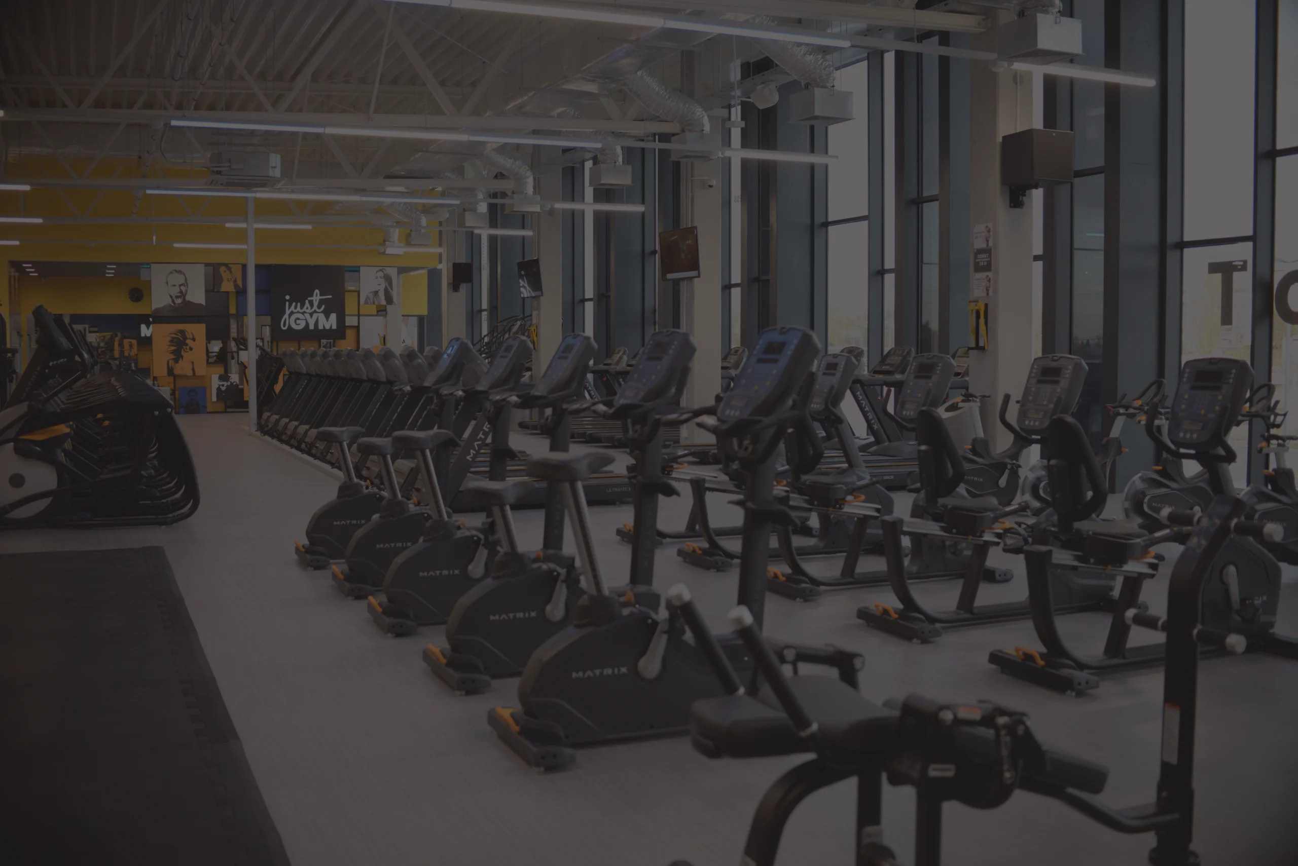 Сучасний фітнес-клуб Just GYM, кардіозона біля великих вікон.