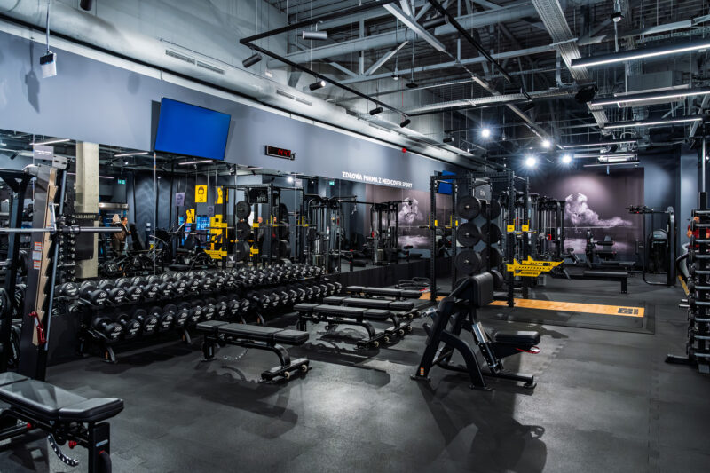 A view of the free weights area at Just GYM BOX gym ursus warsaw with dumbbells, benches and strength machines.