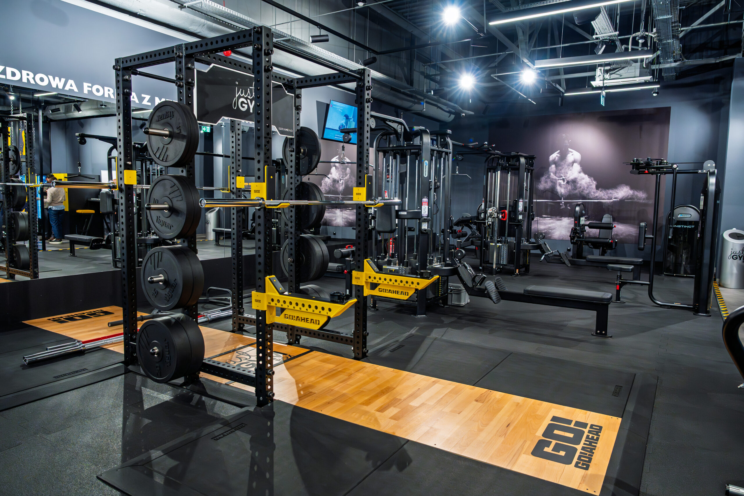 Зона для пауерліфтингу в Just GYM BOX з тренувальними клітками, штангами та платформами для важкої атлетики. Gym ursus warsaw 24h