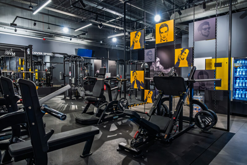 The interior of the gym at the ursus Just GYM BOX with its state-of-the-art workout machines, industrial décor and wall decorations.