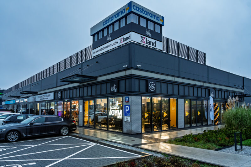 Modern ursus gym building Just GYM BOX with large shop windows, view from the car park, illuminated gym interior in the evening.