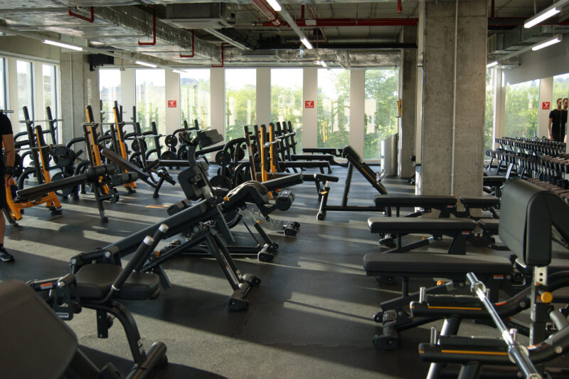 A modern strength zone at Just Gym Łódź Piotrkowska with training machines and benches in a bright, spacious interior.