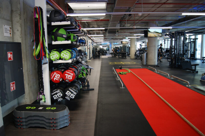 Functional training zone at Just Gym Łódź Piotrkowska - red training track, Corebag balls and fitness equipment.