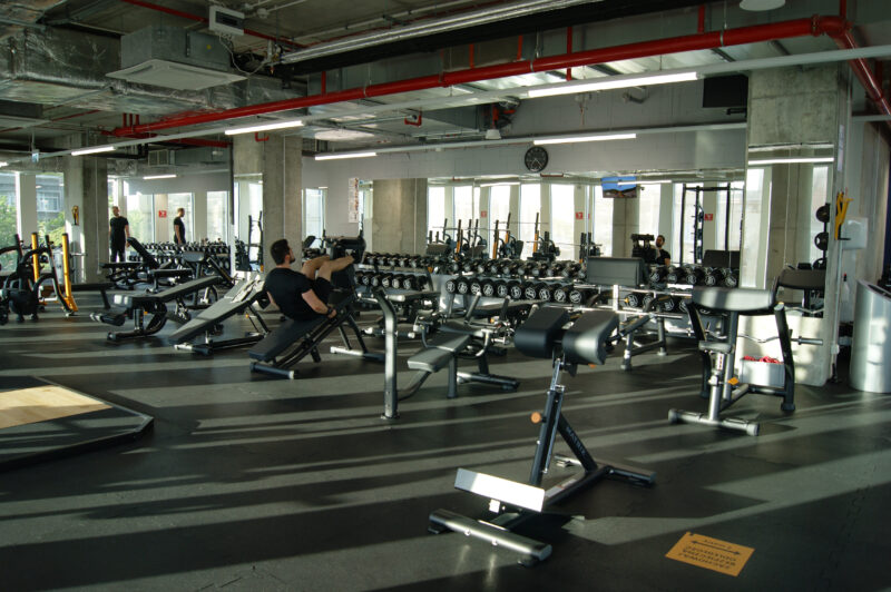 The free weights zone at Just Gym Łódź Piotrkowska - a space with benches, dumbbells and weight training machines.