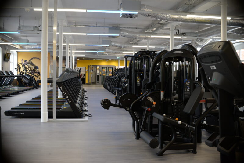 Nowoczesna siłownia Just Gym Racibórz – sprzęt do ćwiczeń siłowych i bieżnie w przestronnej sali.