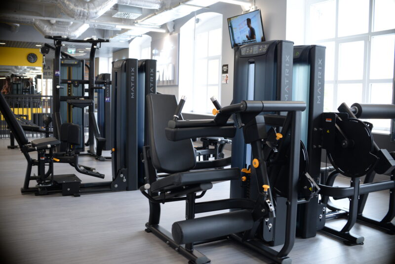 Nowoczesny sprzęt do ćwiczeń siłowych Matrix w klubie Just Gym Racibórz – jasna przestrzeń fitness.