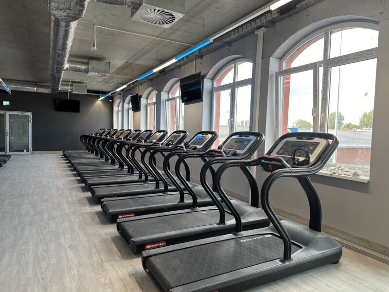 Strefa cardio Just Gym Ruda Śląska – bieżnie Star Trac w jasnej sali z dużymi oknami.
