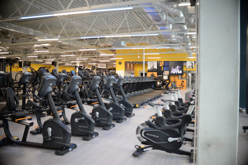 Modern gym Just Gym Słupsk - treadmills, orbiters and Matrix exercise bikes in a bright interior.