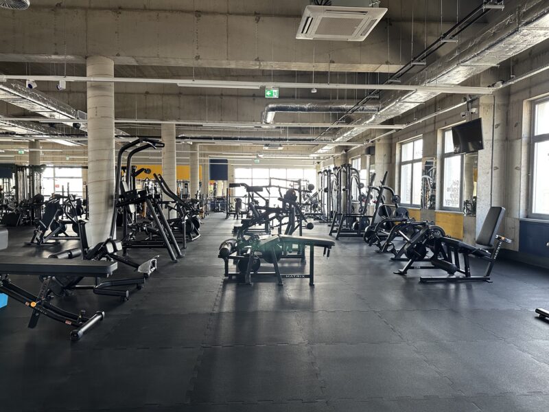 Matrix strength machines in the Just Gym Szczecin club - a spacious workout room with an industrial ceiling.