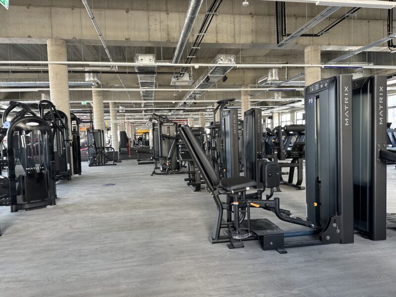 Just Gym Szczecin strength machines zone - modern training equipment in an industrial arrangement.