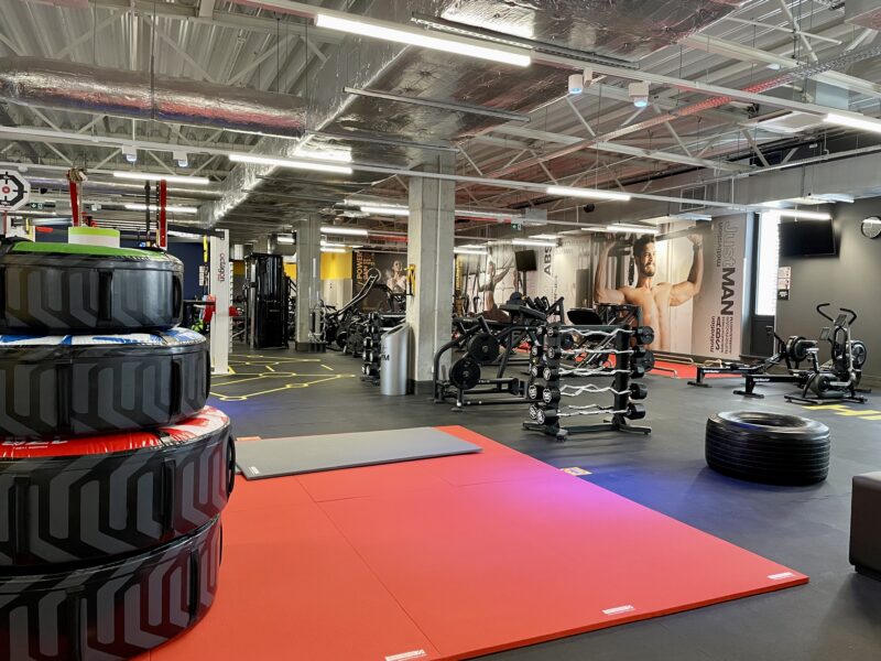 Functional training zone at Just Gym Gniezno with mats, tyres and equipment for strength and endurance training.