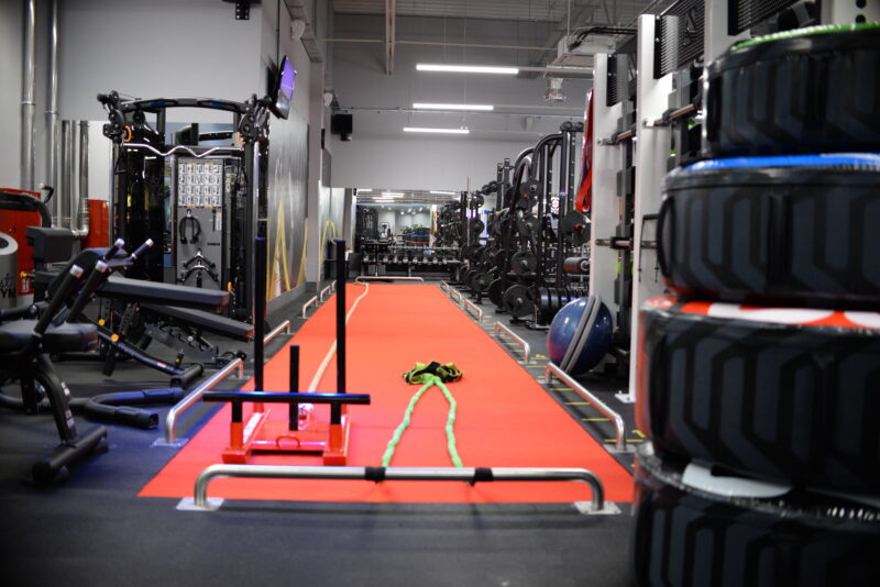 Functional training zone at Just Gym Pabianice - red training track, dumbbells and strength equipment.