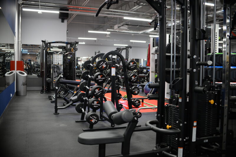 Just Gym Pabianice - dumbbells, machines and a modern workout space with a red training track.