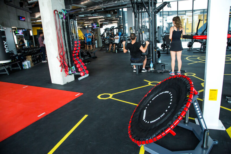 A state-of-the-art functional training area at Just Gym Opole with a red track, trampoline and fitness equipment.