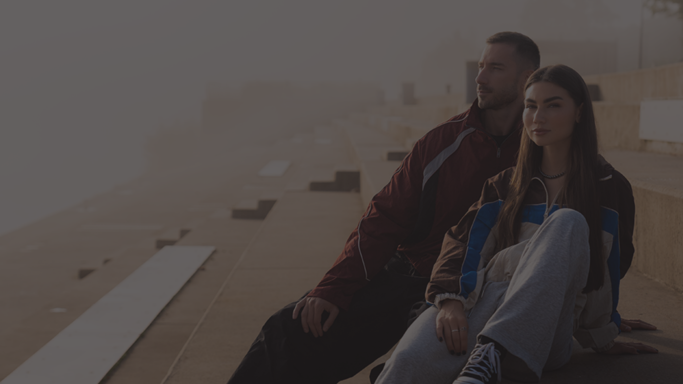 Para w sportowych ubraniach siedząca na betonowych schodach, nowoczesny lifestyle i aktywność fizyczna