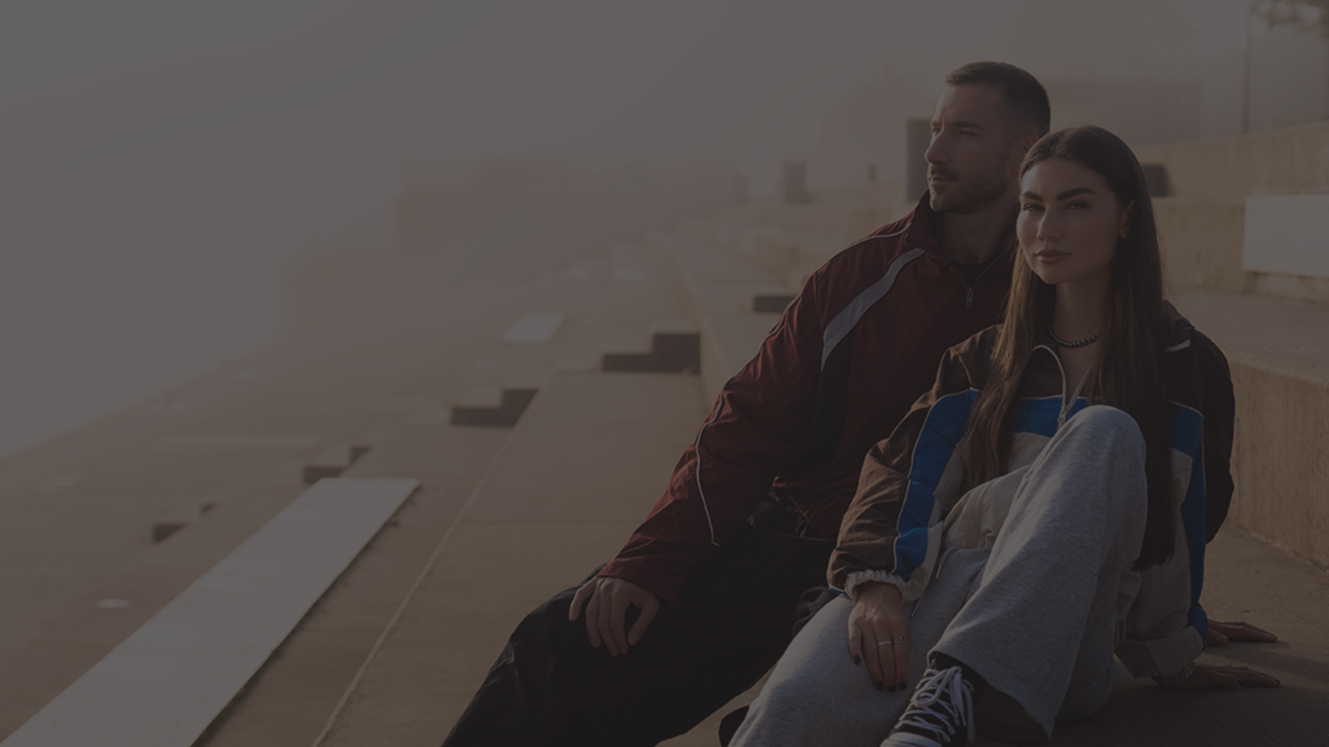 Para w sportowych ubraniach siedząca na betonowych schodach, nowoczesny lifestyle i aktywność fizyczna