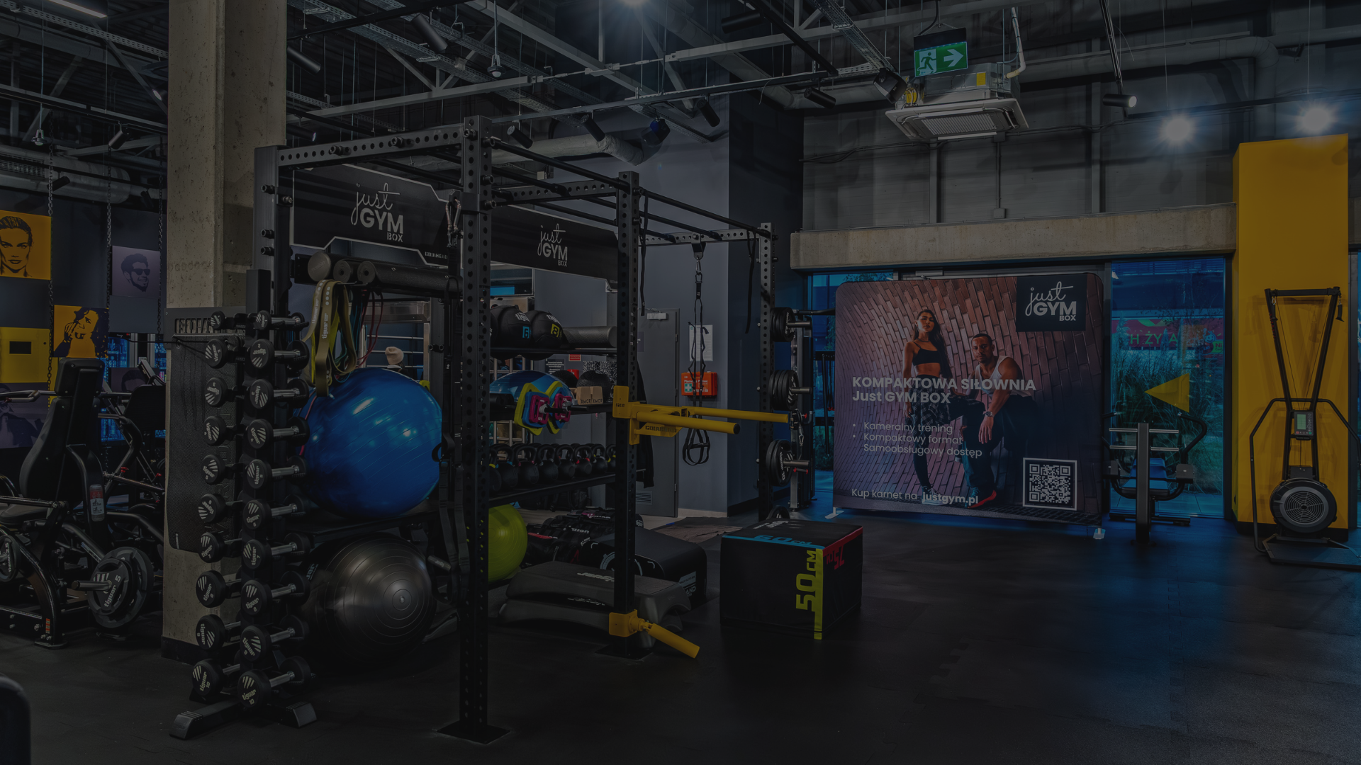 Strefa treningu funkcjonalnego w silownii ursus Just GYM BOX z piłkami, kettlami, boxami plyometrycznymi i klatką treningową.